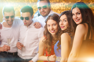 Party people dancing in club. Men and women celebrate a holiday, a birthday or a new year.