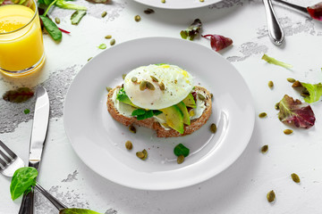 Sandwich, toast with avocado, soft cheese and poached egg on white background