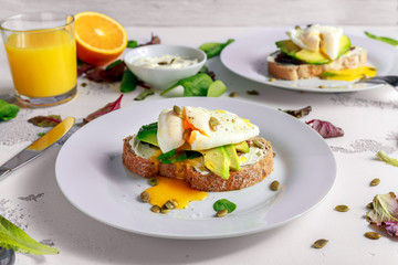 Sandwich, toast with avocado, soft cheese and poached egg on white background