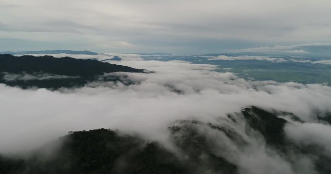 Aerial View. Flying over the beautiful mountain in clouds.