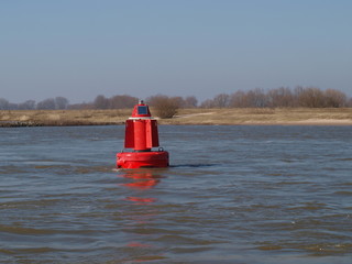 Red buoy on the river Waal in the Netherlands