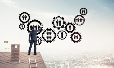 Businessman on house roof presenting teamwork and connection con