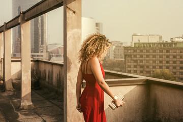 Beautiful and elegant woman portrait walking on building roof in the sunlight