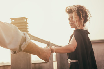 Beautiful woman portrait hand in hand with her lover on building roof