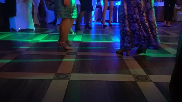 Cropped image of people's feet dancing on a floor .