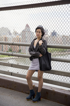 Young woman standing on a bridge in Queens
