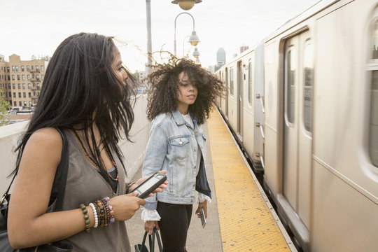 Young women waiting at a train station in Queens, New York