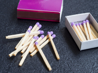 Allumettes éparpillées et boîte d'allumettes mauve ouverte (gros plan)
