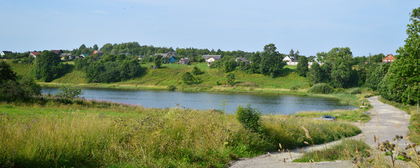 Панорама сельского пейзажа с рекой летним днём.