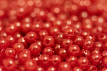 Multicolored blanks for beads close-up. Macro photo on a red background