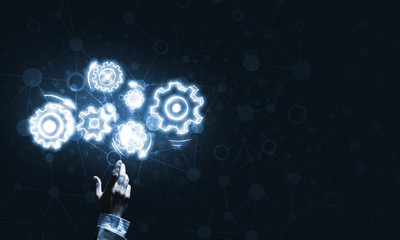 Glowing cogwheel mechanism icon on dark background as symbol of teamwork