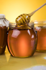 Honey jar, flower with dipper and flowing honey