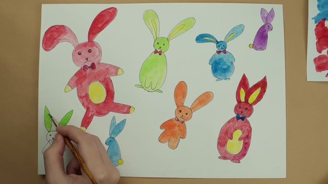 Coloring by watercolor paints of Easter rabbits