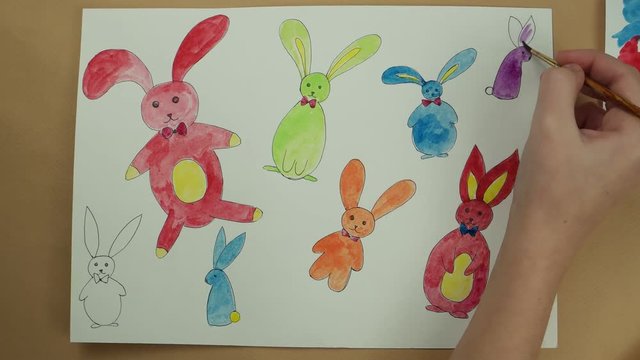 Coloring by watercolor paints of Easter rabbits
