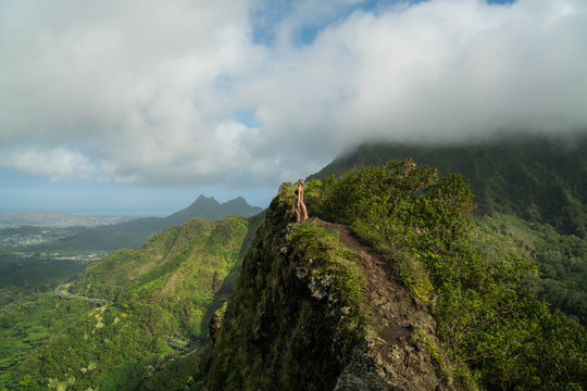 woman standing on mountain ridge