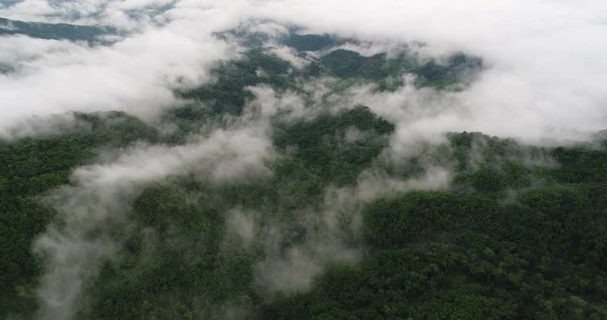 Aerial View. Flying over the beautiful mountain in clouds.