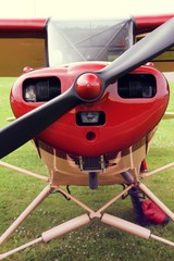 Engine and propeller of small private lightweight vintage airplane closeup image.