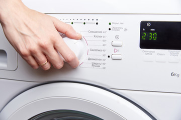 A woman's hand launches a washing machine