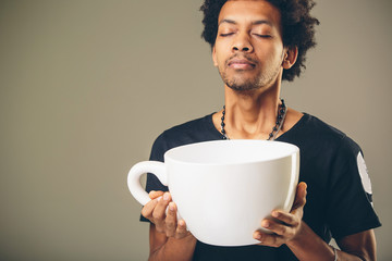 man holding funny huge and oversized cup of black coffee