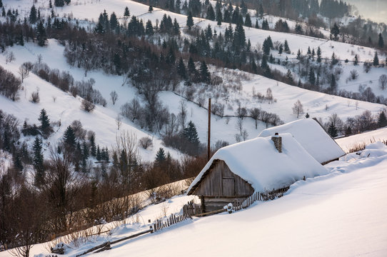 woodshed on hillside in deep snow