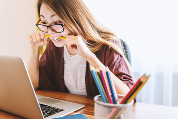Young woman is tense while looking at laptop. Study woman.