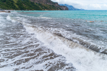 Series of photos as waves with foam roll on a sandy beach