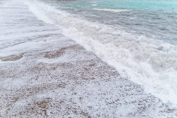 Series of photos as waves with foam roll on a sandy beach