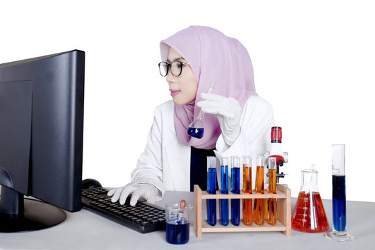 Researcher works with test tube and computer