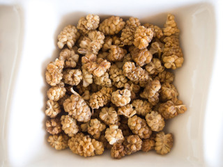 close-up dried white mulberry on white plate
