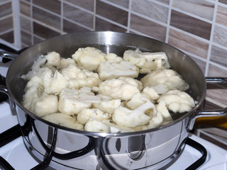 cauliflower boiled in a pan on a cooker in the kitchen