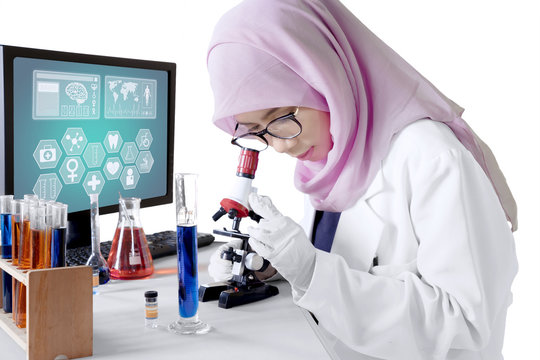Muslim scientist looking through a microscope