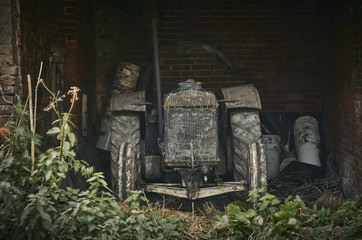  The front of a  vintage tractor in anold brick barn