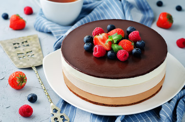 Triple chocolate mousse cake decorated with fresh berries