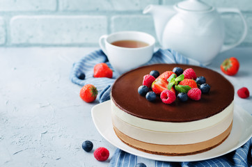 Triple chocolate mousse cake decorated with fresh berries