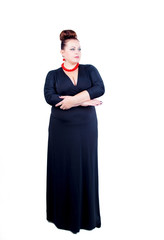 Obraz na płótnie Canvas Beautiful confident buxom woman in black evening dress in full, with red costume jewelry stands isolated in full growth on a white background