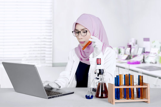 Asian scientist working with laptop