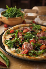 Traditional pizza with prosciutto and arugula