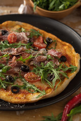Traditional pizza with prosciutto and arugula