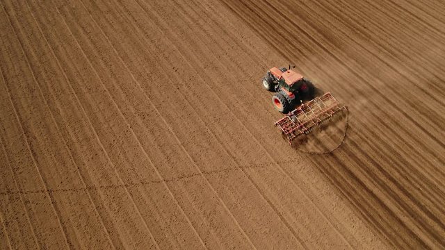Drone aerial shot of a farmer cultivating arable field