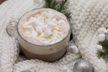 Obraz na płótnie Canvas delicious hot cocoa with marshmallows on the Christmas table Christmas balls, fir branches knitted scarf warmth and comfort