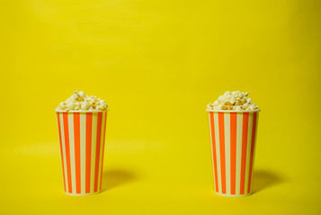 ポップコーンとポップコーンカップ２個　シンプル素材　黄色背景