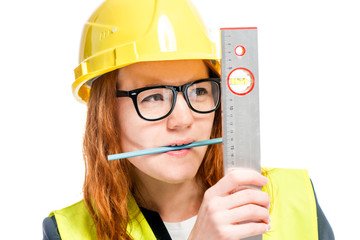 portrait of a concentrated foreman with a ruler and a pencil in the teeth isolated