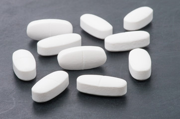 Obraz na płótnie Canvas White pills on the black