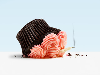 Accident, dropped cupcake with candle and smoke on blue background