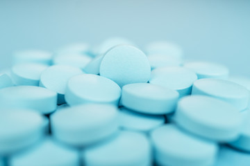 pile of blue pills close-up on the background. shallow depth of field
