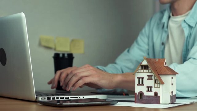 Graphic designer using graphic tablet creating housing project on laptop