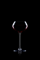 Fototapeta na wymiar Glass of red wine on black with reflection