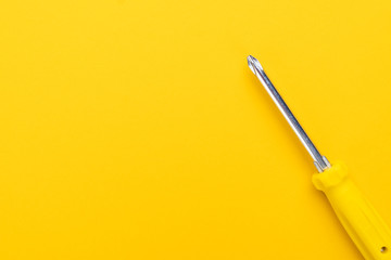 close-up of manual screwdriver with plastic handle on the yellow background