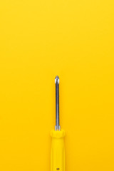 close-up of manual screwdriver with plastic handle on the yellow background