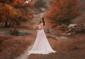 A happy bride in a beautiful, powdery dress. Wedding walk in the fairy, autumn forest